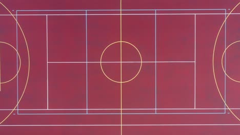 Birds-Eye-Aerial-View-of-Empty-Basketball-Field,-Lines-on-Red-Court