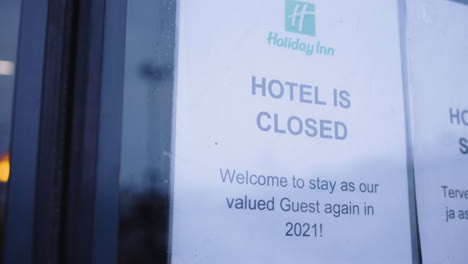 Handheld-shot-of-sign-saying-Holiday-Inn-hotel-is-closed-until-2021