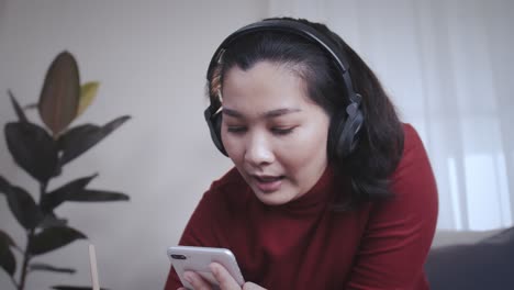 Geschäftsfrau-Redshirt-Mit-Einem-Tablet-Mit-Kopfhörer-Für-Online-treffen-Zu-Hause