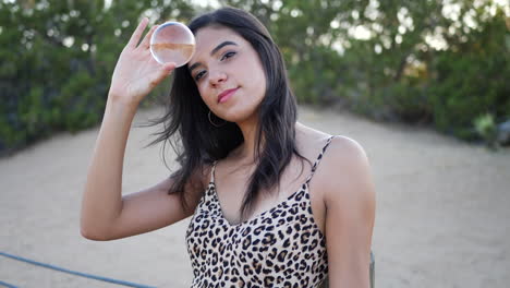 A-beautiful-hispanic-woman-holding-a-magic-crystal-ball-and-smiling-SLOW-MOTION