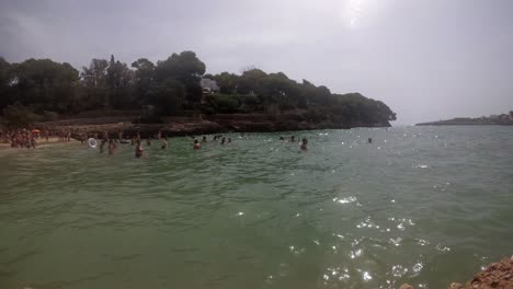 España-Mallorca-Playa-Cala-D&#39;or-4k-A-60fps-Con-Olas-Yi-4k-Y-Gente-En-Un-Día-Nublado-Por-La-Tarde
