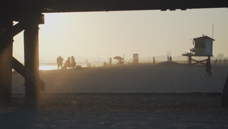 People-and-a-lifeguard-station-seen-through-the-Seal-Beach-pier