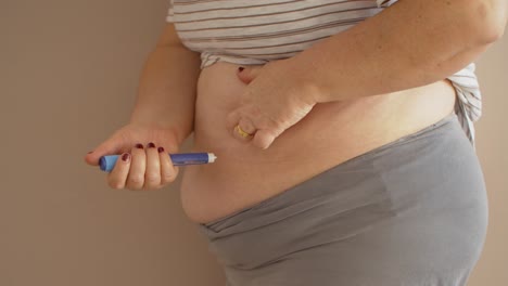 Woman-applying-diabetes-medicine-into-her-belly-in-slow-motion