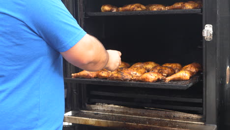 Man-checking-the-temperature-of-BBQ-Chicken-in-an-off-set-BBQ-smoker