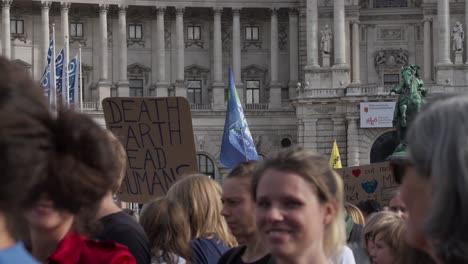 Close-up-of-crowds-gathered-during-protests-in-Vienna,-with-backdrop-of-national-library