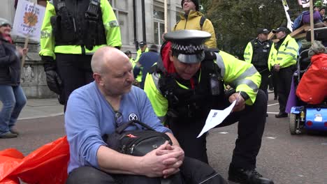Die-Polizei-Informiert-Einen-Demonstranten,-Dass-Er-Sich-Während-Der-Proteste-Gegen-Das-Aussterben-Der-Rebellion-In-London,-Großbritannien,-Bewegen-Muss