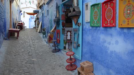 Chefchaouen-tradicional-blue-street-with-local-store-displaying-popular-art