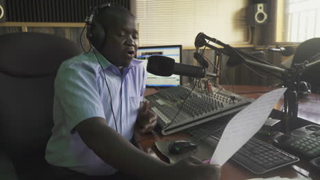 Locutor-De-Radion-Leyendo-Noticias-De-Una-Hoja-De-Papel-En-La-Estación-De-Radio-Local-En-Uganda