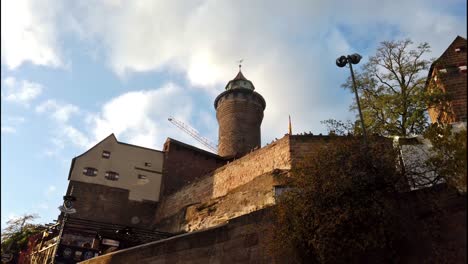 Slow-walk-below-the-Kaiserburg-in-Nuremberg-with-camera-tracking-of-its-main-tower