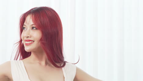 Beautiful-young-Asian-ballerina-woman-with-long-red-hair-dancing-smiling-happy-in-the-white-room