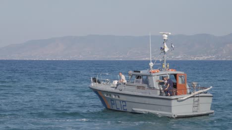 Port-police-watching-the-illegal-immigrants-as-they-arrive-by-boat-at-Latchi-Polis-Chrysochou,-Cyprus