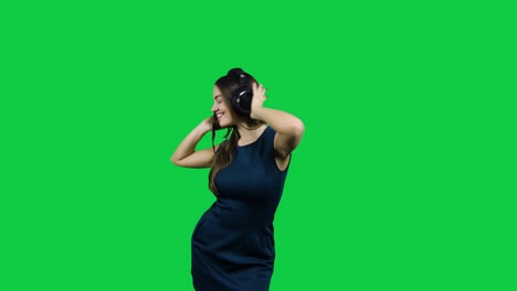 Glückliches-Mädchen-Mit-Kopfhörern,-Die-Vor-Dem-Grünen-Bildschirm-Tanzen