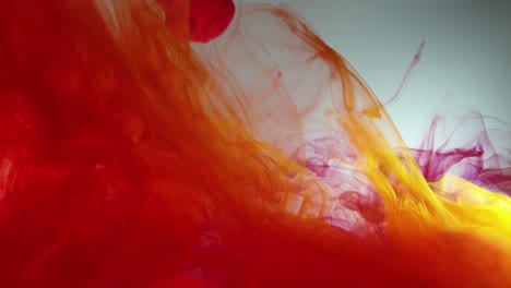 Colorful-cloud-swirls-of-red-and-yellow-acrylic-dye-ink-falling-slowly-into-water,-prismatic-multi-color-overload-and-very-mesmerizing-footage