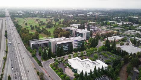 Aerial-hold-of-Samsung-Research-America-SRA-campus-in-Silicon-Valley-with-green-pine-trees-landscape-under-overcast-sky