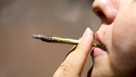 Cannabis,-marijuana,-light-drugs,-woman-smokes-a-joint,-close-up,-slow