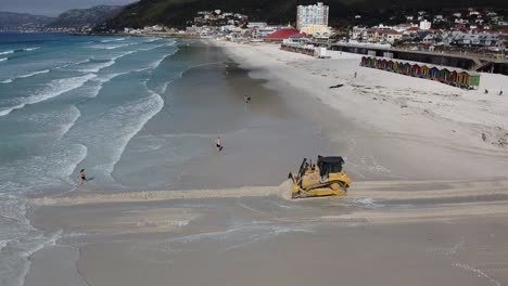 A-heavy-machinery-Caterpillar-bulldozer-opens-a-passage-for-water-to-flow-from-Zandvlei-Estuary-Nature-Reserve-into-the-Muizenberg-beach