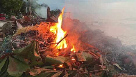 Burning-leaves-and-plastic-at-beach-of-Gili-Air-Island,Indonesia