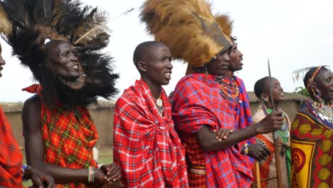 Erstaunliche-Darstellung-Der-Stammestradition-Durch-Die-Massai-Krieger-Und-Die-Frauen-Im-Dorf,-Die-Ihre-Traditionellen-Outfits-In-Kenia-Tragen
