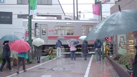 Train-Passing-Through-Local-Town-On-A-Rainy-Day-In-Tokyo-Japan---slow-motion-shot