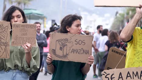 Kind-Hält-Ein-SOS-Amazonas-Schild-In-Rio-De-Janeiro,-Brasilien,-Während-Eines-Straßenprotestes-Für-Den-Schutz-Des-Amazonas-Waldes