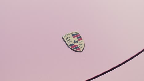 Zoom-out-on-a-Porsche-logo-on-top-of-pink-color-hood