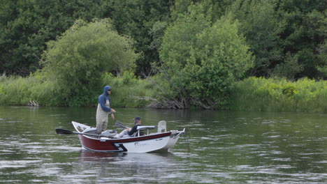 Two-friends-fly-fishing-from-small-boat-on-Snake-River,-Idaho