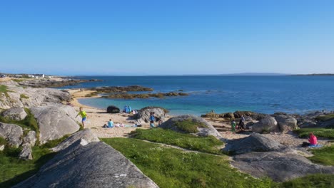 People-Relaxing-On-The-Beach-Shore-Of-Coral-Strand-DUring-Summertime-in-Connemara,-County-Galway,-Ireland