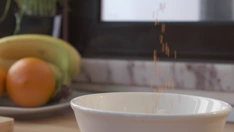Pouring-Cereals-Into-A-White-Bowl-In-The-Kitchen---extreme-slow-motion