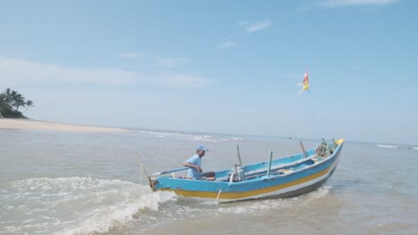 bright-blue-and-yellow-Indian-fishing-boat-going-out-to-sea-slow-motion