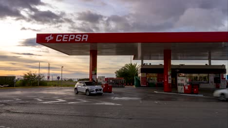Cepsa-Tankstelle-Zeitraffer-Mit-Autos-Und-Menschen,-Die-Sich-Bei-Sonnenaufgang-Bewegen,-Fossile-Brennstoffe