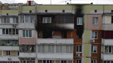 Un-Dron-Disparó-Hacia-Apartamentos-Y-Ventanas-Quemados-Y-Llenos-De-Hollín-En-Un-Edificio,-En-Un-Barrio-Pobre-De-Kyiv,-Día-Nublado,-En-Kiev,-Ucrania---Vista-Aérea-De-Dolly