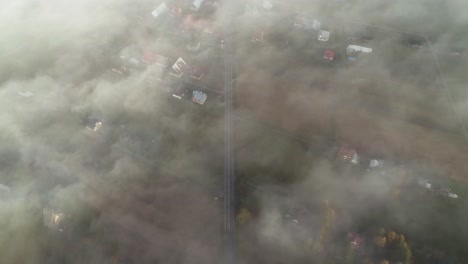 Mist-above-rural-village-covered-in-light-mist,-Chochołów-in-Poland,-aerial