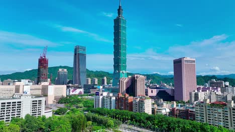 Aerial-view-of-green-trees-and-high-buildings-with-101-tower-in-Taipei-City-during-sunny-day-and-blue-sky,Taiwan
