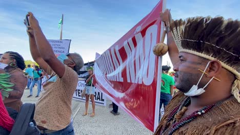 indigenous-brazilian-people-with-feathered-headdresses-holding-a-banner-on-the-protest-in-front-of-the-supreme-court-of-brasilia-against-murder-and-violence-on-dom-phillips-and-bruno-pereira