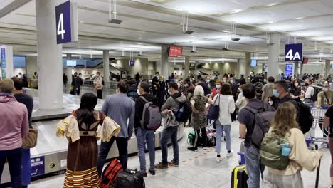 Passengers-patiently-waiting-for-their-bags-at-the-airport-caroussel