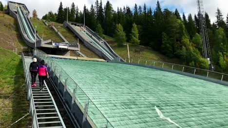 Ski-jump-practice-on-the-large-hill-at-the-Lillehammer,-Norway-1994-Winter-Olympic-Park-during-summer---slow-motion-ramp