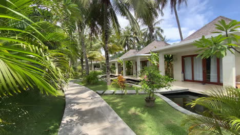 Dolly-Right-Past-Palm-Leaves-To-Reveal-Luxury-Resort-Villas-In-Kuta,-Lombok