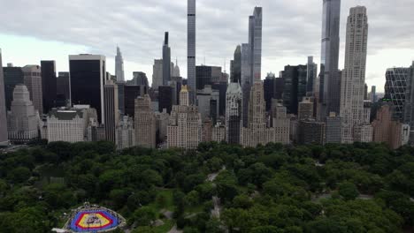 Central-Park-and-a-wall-of-high-rise-buildings-in-cloudy-MIdtown,-NYC,-USA---Aerial-view