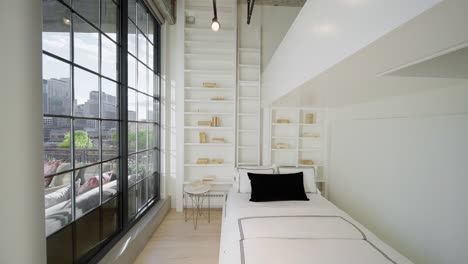 unique-modern-bedroom-next-to-large-windows-looking-out-at-a-city-skyline