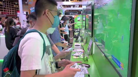 Gamers-play-videogames-using-a-controller-from-the-American-video-gaming-brand-owned-by-Microsoft,-Xbox-S-and-X-series,-system-during-the-Ani-com-and-Games-ACGHK-exhibition-event-in-Hong-Kong