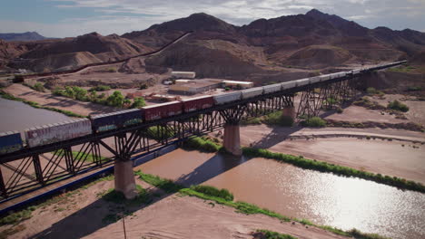 A-train-is-stopped-on-a-bridge-over-the-Rio-Grande-in-El-Paso,-Texas
