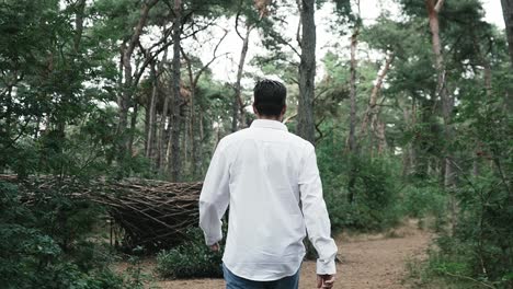 man-walking-in-the-green-Belgian-forest-with-very-nice-clothes