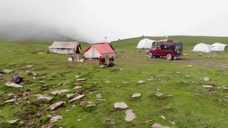 The-largest-district,-Neelum,-in-the-Muzaffarabad-division-of-Kashmir-Pakistan,-which-is-filled-in-greenery,-and-steep-rocks-has-people-are-standing-in-the-grass-and-a-tent-set-up-there