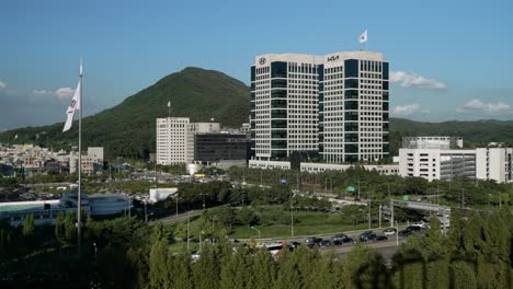 Seoul-cuty-skyline-with-a-view-of-Hyundai-Motor-Group-HQ-buildings-against-mountains-and-cars-driving-on-Gyeongbu-expressway-on-in-Seocho-gu,-Seoul