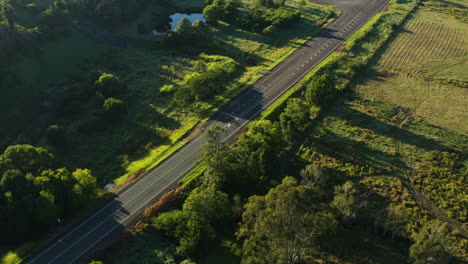 Radfahrer,-Der-Entlang-Der-Malerischen-Ländlichen-Landschaftsstraße-In-Australien-Fährt,-Antenne-4k-Drohne