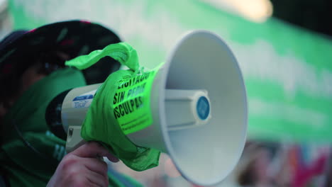 Un-Manifestante-Con-Un-Pañuelo-Verde-Grita-En-Un-Megáfono-En-Una-Protesta-Pro-Elección-En-El-Centro
