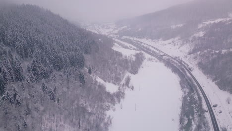 Drone-Levantándose-Mostrando-La-Belleza-Del-Invierno-En-El-Campo-Con-Un-Camino-Que-Pasa-Y-árboles-A-Ambos-Lados-Del-Camino