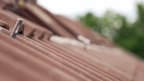 Closeup-rack-focus-of-roof-tiles-with-installed-rails-mount-for-solar-panel