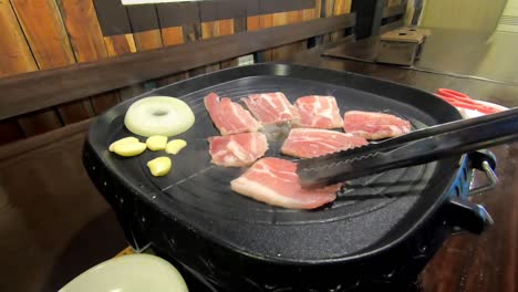Samgyeopsal-Kochen,-Ein-Koreanisches-Essen-Bestehend-Aus-Schweinebauch,-Zwiebeln,-Knoblauch
