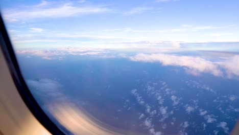 Helle-Und-Schöne-Blaue-Himmelslandschaft,-Höher-Schwebende-Wolken-Und-Sonne,-Raum-Schicht-Für-Schicht,-Schießen-Sie-Ein-Flugzeugfenster